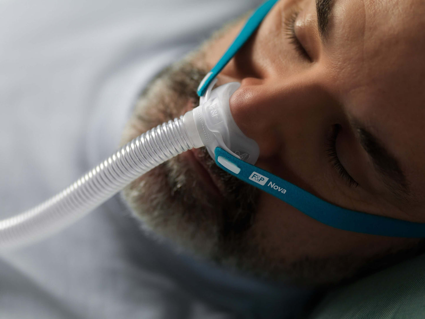Un homme dort avec le Nova Micro (gros plan)