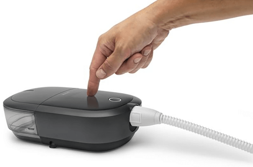 Doigt touchant la machine Dreamstation 2 CPAP