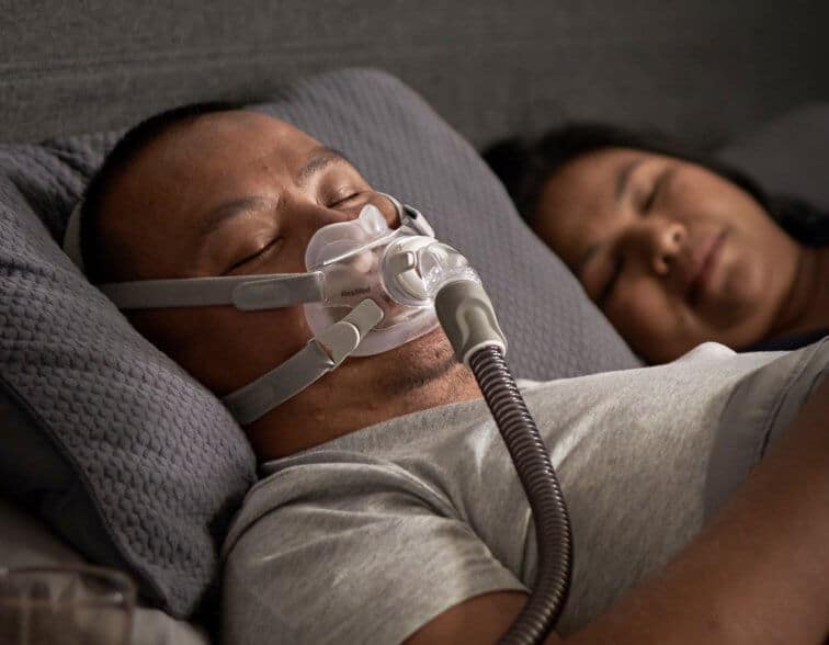 Un homme dort avec le masque AirFit F30