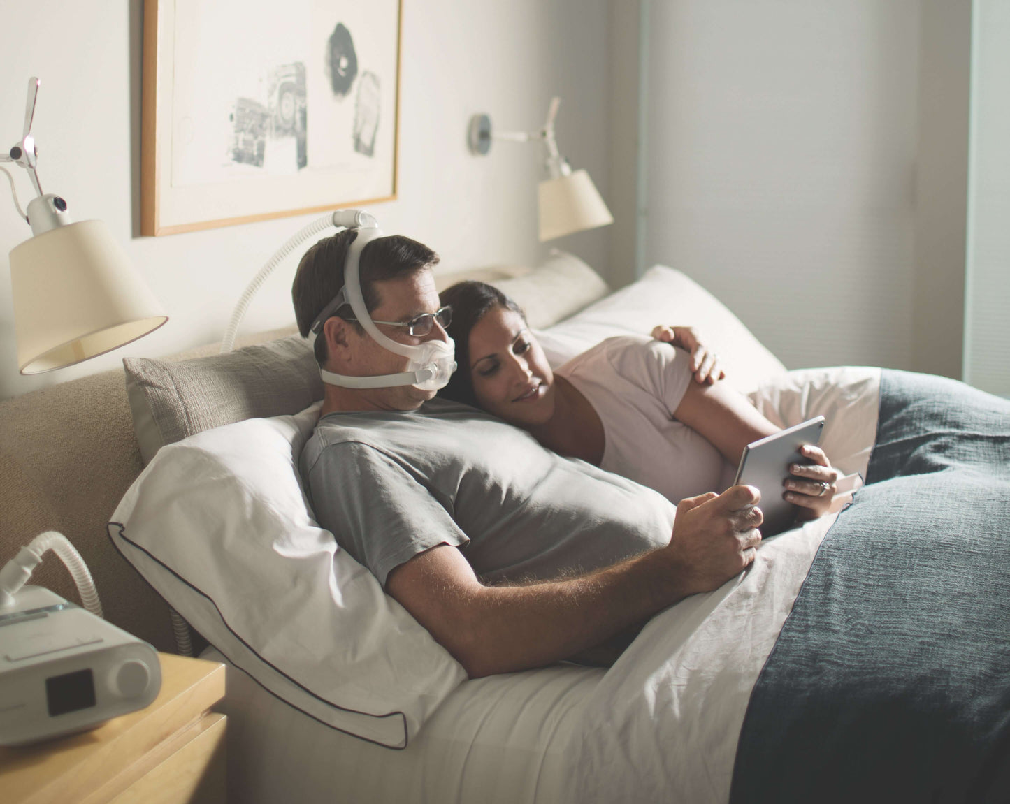 man wearing his dreamwear mask whilst watching his tablet