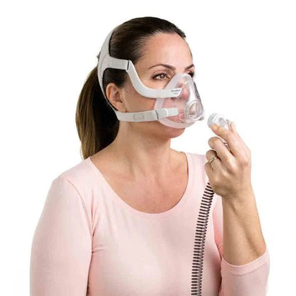 femme portant le masque Airfit F20 pour elle en train de connecter sa tubulure