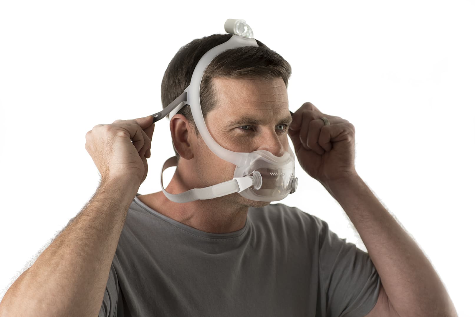 homme mettant son masque dreamwear de respironics