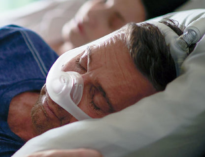 homme coucher sur son côté en portant le masque dreamwisp de respironics
